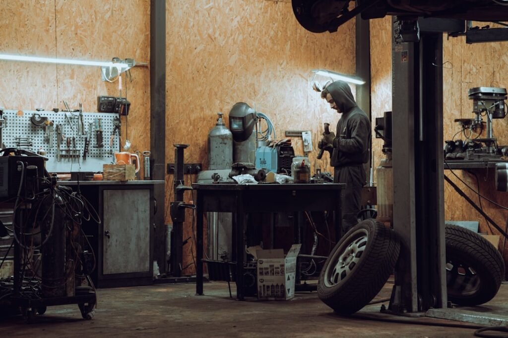 Workshop technician using protective gloves while working safely in an automotive workshop
