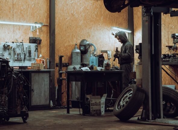 Workshop technician using protective gloves while working safely in an automotive workshop